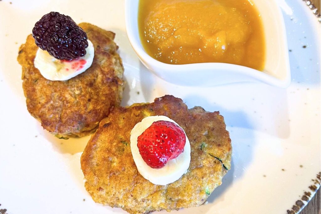 Baby Led Weaning Dinkelvollkorn Pancakes schön angerichtet mit Banane und Erdbeere oben drauf auf Teller.