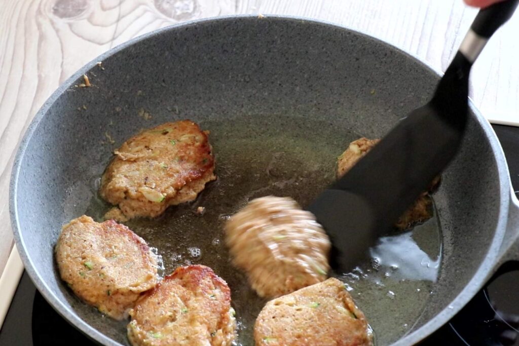 BLW Rezept Dinkelvollkorn Pancakes Frau wendet die Pancakes in der Bratpfanne