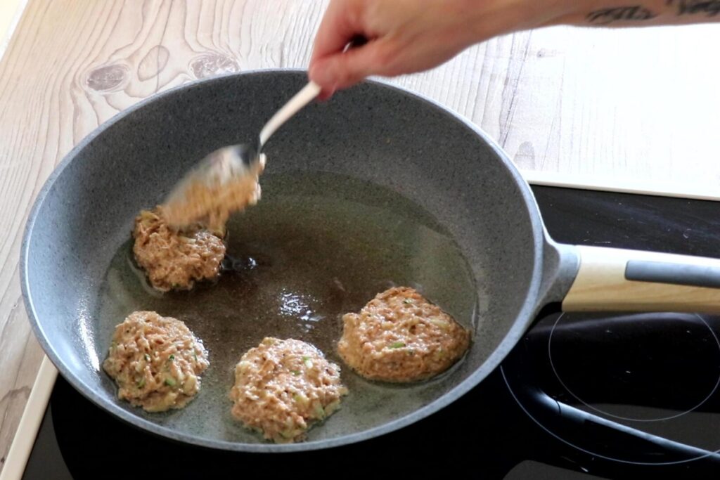 BLW Rezept Dinkelvollkorn Pancakes Frau gibt jeweils einen Esslöffel des Teigs in Bratpfanne